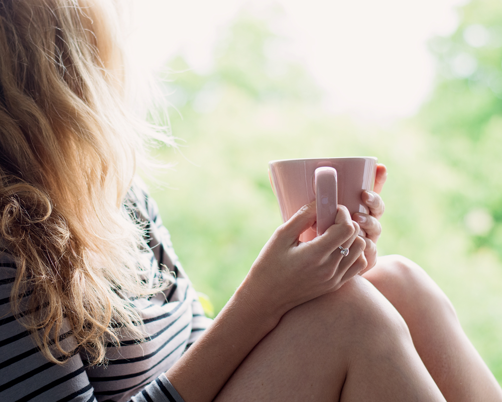 Frau macht bewusst eine Pause im Alltag, um ihr Nervensystem zur Ruhe kommen zu lassen.